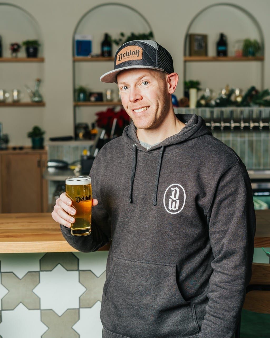 Tony Jarvis, General Manager at DeWolf Brewing, holding a beer